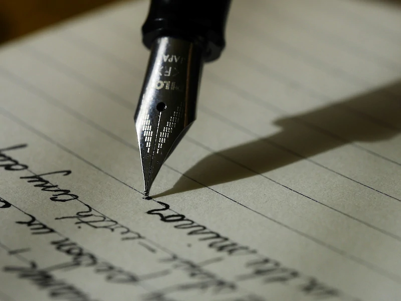 Penna a stile che scrive qualcosa su un foglio di carta